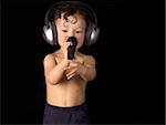 Sing baby with headphone and microphone, on a black background.