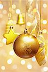 Golden Christmas Ornaments hanging with blur light on background