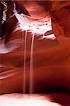 Light play with the stream of falling sand from the red rock of the Antelope Canyon