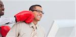 Young businessman being boxed in the office while he is working