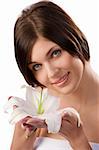 nice beauty shot of a young brunette showing a white lily looking in camera smiling