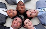 Multi-ethnic business team lying on the floor with heads together. Business concept.