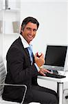 Smiling businessman holding a red apple