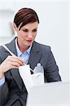 Young businesswoman eating with chopstick in the office