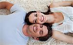 Smiling Couple lying on the floor with heads together