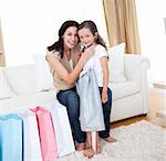 Happy mother and little girl after shopping  in the living-room