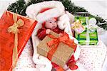 baby in santa costume with presents