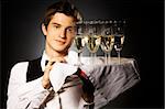 professional waiter in uniform is serving wine