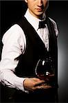 professional waiter in uniform is serving brandy