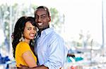 Young romantic couple hugging and standing at harbor