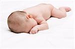 Beautiful little baby lying on the bed isolated over white
