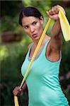 Young woman exercising in outdoor setting. Vertically framed shot.