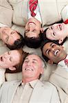 Laughing Business team lying in a circle with heads together