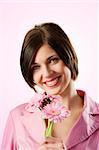 beautiful young woman in pink with flowers looking in camera with a great smile