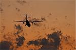 Sunset scene with silhouette of a landing plane