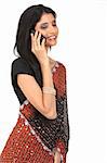 teenage girl with black sari standing in white background talking with cellphone