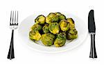 Plate of roasted green brussels sprouts with knife and fork isolated on white
