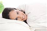 Front view portrait of beautiful resting woman cover in white sheet