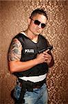 Hispanic Cop Wearing Bulletproof Vest and Holding Small Gun