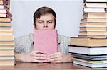 Young student sitting with book and thinking