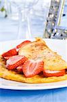 Omelette with sliced fresh strawberries on plate