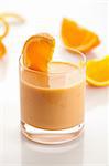 Orange yoghurt in glass with segment of fresh orange