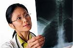 Asian female doctor looking at an x-ray of lungs. Horizontal shot. Isolated on white.