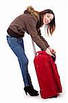 Young women ready for winter travel cheking her suitcase indoor studio
