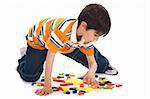 Cute kid inprocess of joining the blocks over white background