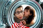 Funny couple loading clothes to washing machine. From inside the washing machine view.