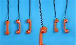 Close-up large group of orange telephones over blue background