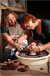 Teacher and student in clay studio working at the wheel