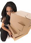 Young adult African-Indian businesswoman in casual office outfit carrying brown cardboard boxes on a white background. Not Isolated