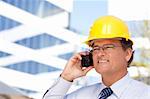Handsome Contractor in Hardhat and Necktie Smiles as He Talks on His Cell Phone.