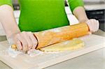 Spreading out cookie dough with wooden rolling pin