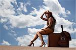 Pretty brunette woman with suitcase and guitar