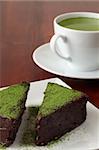 Chocolate cake garnished with Matcha green tea powder and a cup of green tea