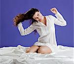 Beautiful and happy young woman smiling on the bed by the morning