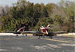 Three light sports airplanes taxiing on the ground