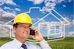 Contractor in Hardhat on His Cell Phone Over House Icon, Empty Grass Field and Deep Blue Sky with Clouds.