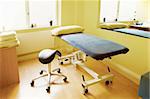 Massage or acupuncture treatment room showing bench and stool