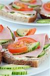 Healthy open faced sandwiches with ham, tomato, cucumber and cream cheese seasoned with freshly ground pepper