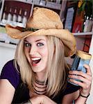 Young blond girl with cowboy hat and coffee