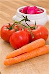 fresh tomatoes, carrot and radish on cutting board