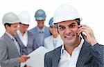 Smiling male architect on phone standing in front of his team