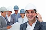 Confident male architect on phone standing in front of his team