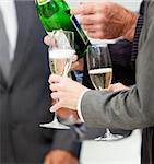 Close-up of a business person serving Champagne in the office