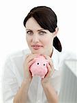Serious businesswoman holding a piggybank isolated on a white background