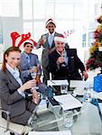 Manager and his team toasting with Champagne at a Christmas party in the office