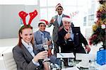 Multi-ethnic busioness team toasting with Champagne at a Christmas party in the office